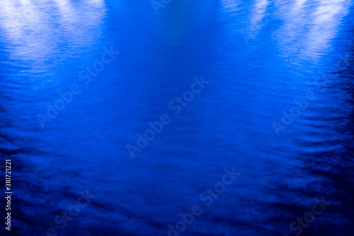 Abstract blue background, lights reflections on the water.