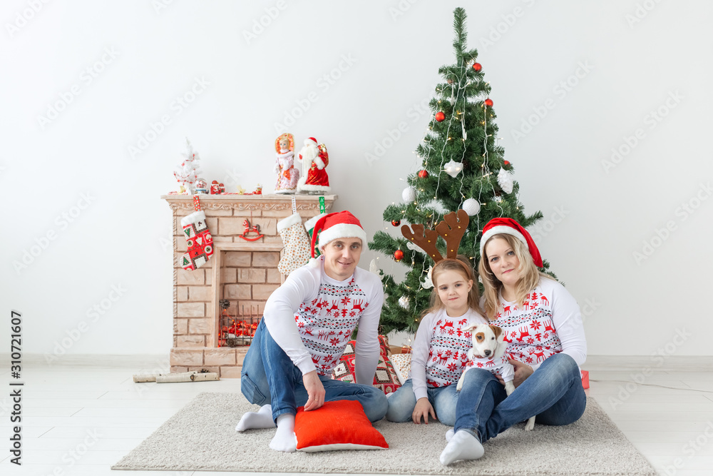 Holidays and festive concept - Happy family portrait by Christmas tree Holidays and festive concept - Happy family portrait by Christmas tree