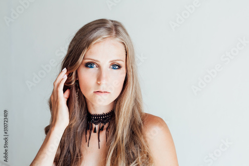 BLONDE GIRL WITH BLUE EYES MAKEUP ON WHITE BACKGROUND