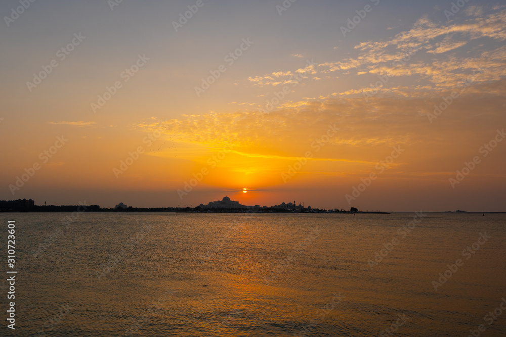 Fototapeta premium Beautiful sunset with lights reflections on the water