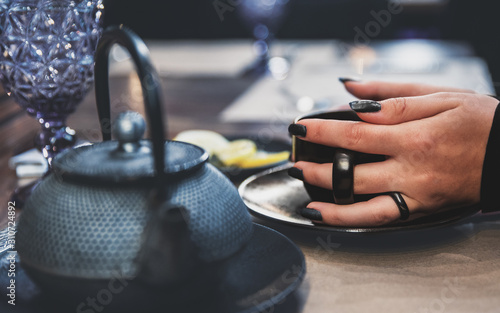 woman hand hold tea cup on table in cafe