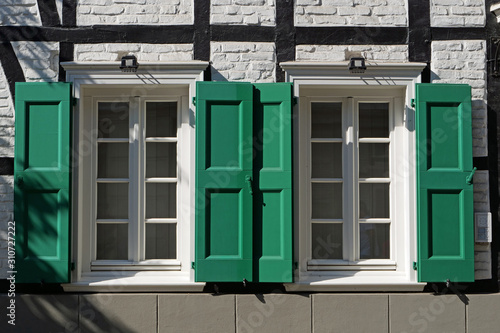 Macro view on two windows with green folding shutters of a timber framed house in Germany, Europe
