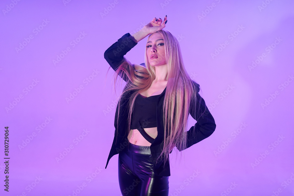 Attractive blonde woman sitting on the chair over pink background Attractive blonde woman sitting on the chair over pink background