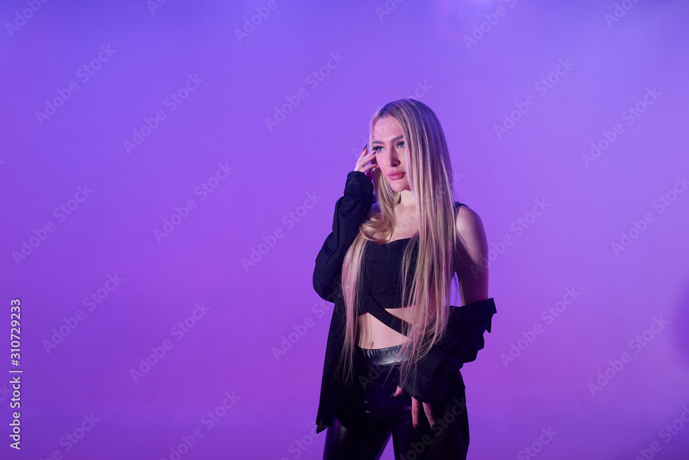 Attractive blonde woman sitting on the chair over pink background