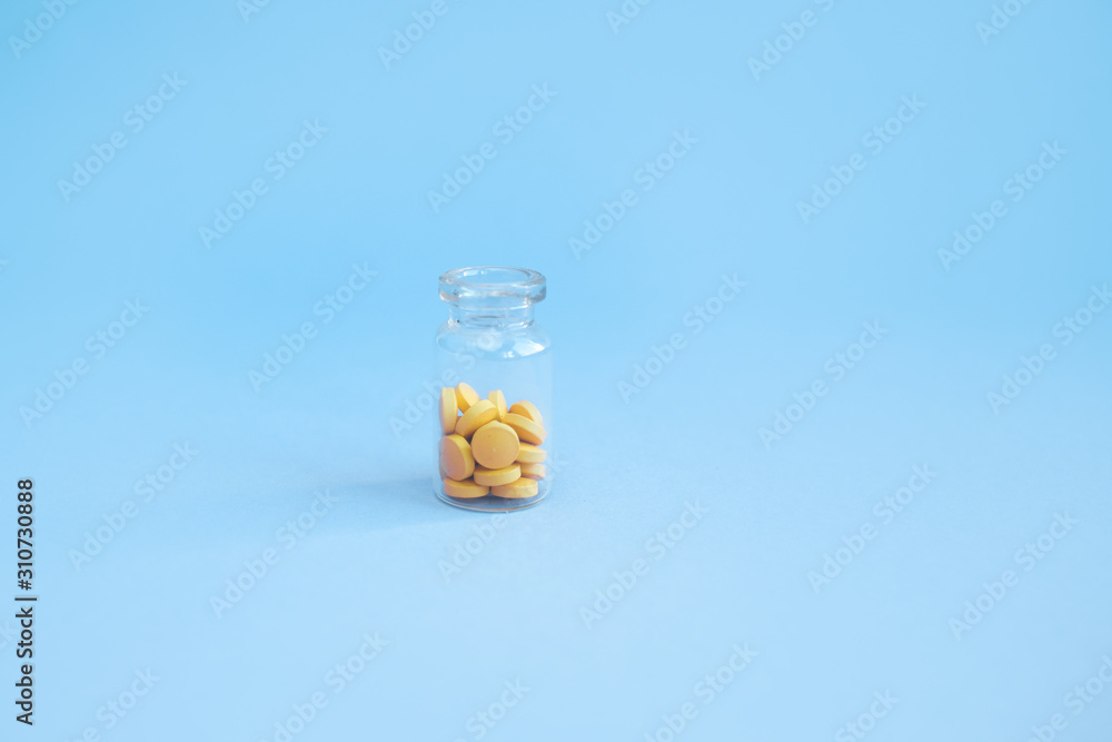homeopathic globules and glass bottle on blue background. Alternative Homeopathy medicine herbs, healtcare and pills concept. Flatlay. Top view. copyspace for text.