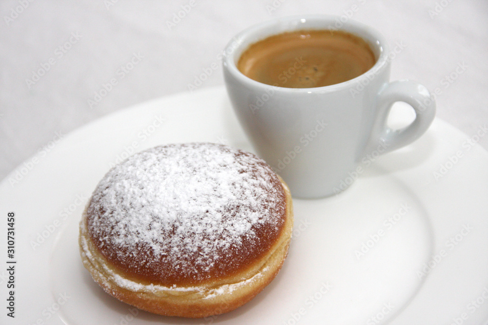 Fresh homemade Austrian Carnival Donut so called Austrian Faschingskrapfen or Berliner, sweet Krapfen filled with apricot jam and icing sugar and espresso on white plate close up on white Background Fresh homemade Austrian Carnival Donut so called Austrian Faschingskrapfen or Berliner, sweet Krapfen filled with apricot jam and icing sugar and espresso on white plate close up on white Background
