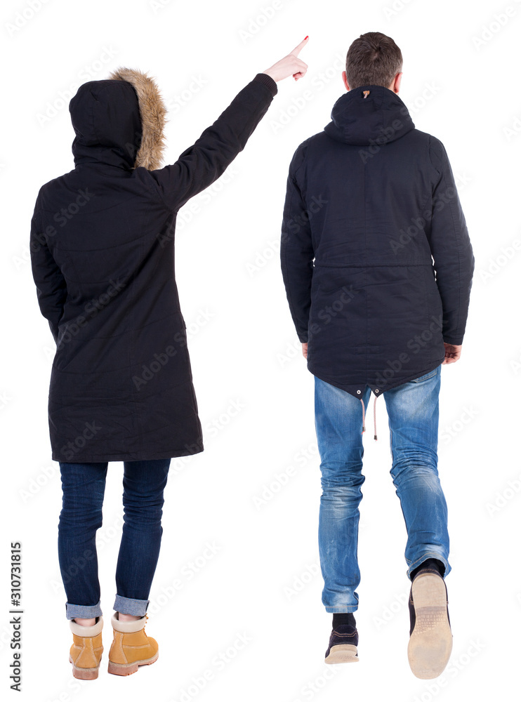 Back view of couple couple in winter jackets pointing. Back view of couple couple in winter jackets pointing.