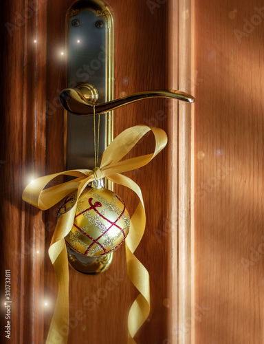 Christmas and New Year golden ball and ribbon as decorative element of the appartment. Christmas and New Year concept.