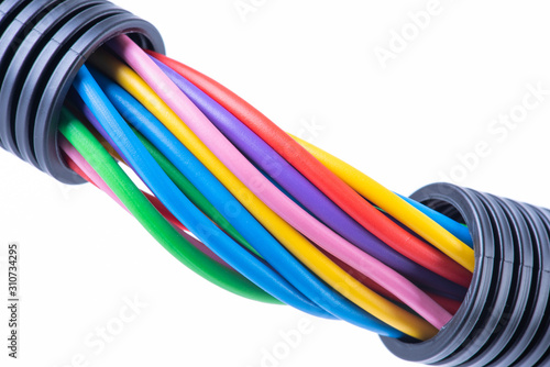 Colorful electrical cables in protective corrugated pipe isolated on white background photo