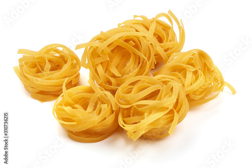 Raw tagliatelle pasta, isolated on white background