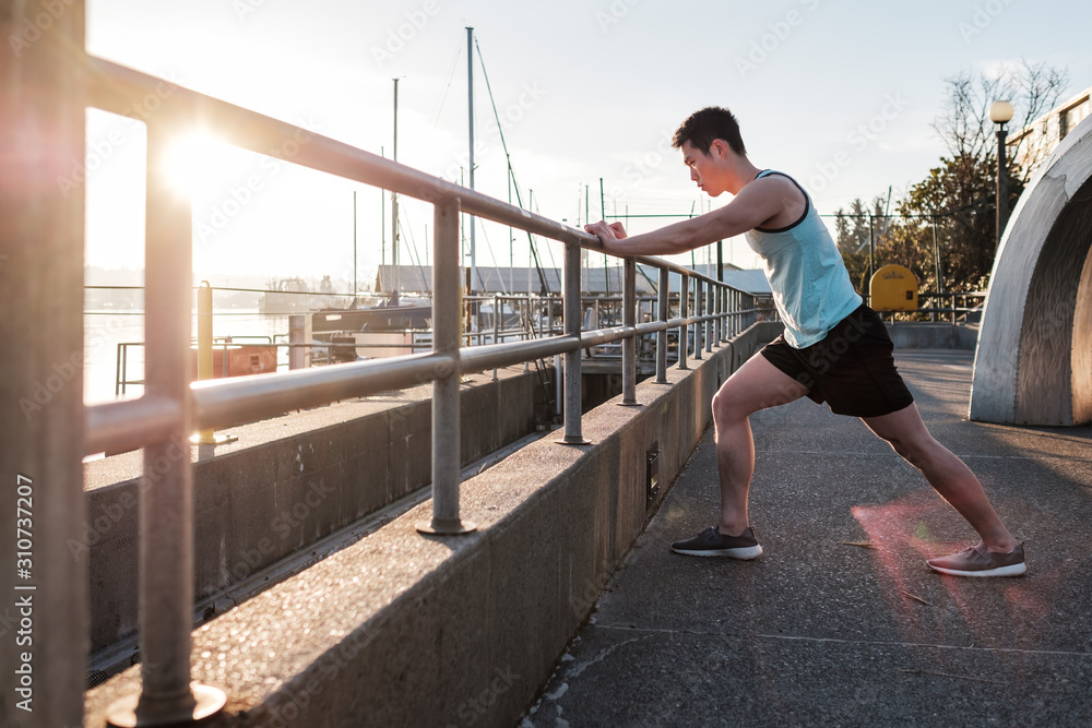 Asian American athlete stretching before exercising Asian American athlete stretching before exercising