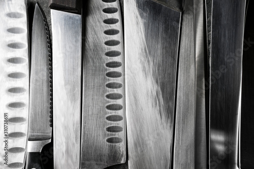 Obraz na płótnie Professional kitchen knives texture on dark stone background. Creative layout. Chef, restaurant or kitchen concept. Top view, copy space w salonie