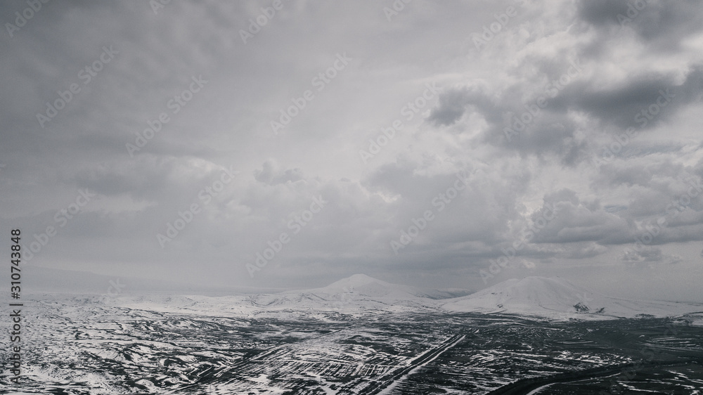 Armenian Spring - car root by the foot of a mountain chain - drone shot Armenian Spring - car root by the foot of a mountain chain - drone shot