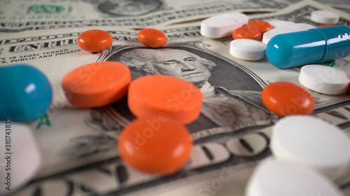 Small denominated dollar bills with pills rotate on a table. Close-up