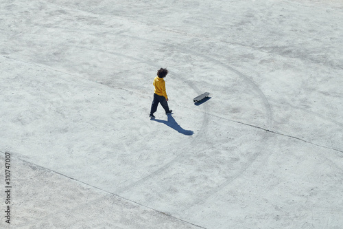 Casual man with skateboard on pavement photo