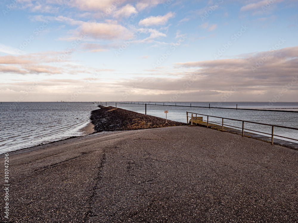 Norddeich, Germany. 7 December 2019.  Concrete dam on the North Sea coast in morning light.