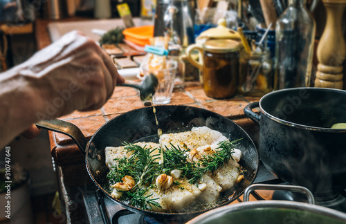 Food: Frying fish with herbs in a pan
