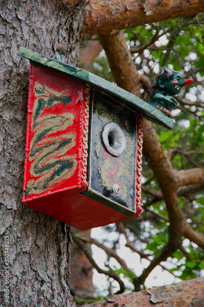 Colourful birdhouse with troll as guard Colourful birdhouse with troll as guard