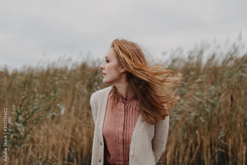 Young redhead woman in the tall grass. Young redhead woman in the tall grass.