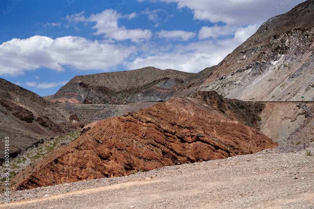 Dead nature Mojave Desert. In southern California, southeast of Sierra Nevada, north and east of Los Angeles, North America. The rocks are brown and gray. Clouds in the blue sky
