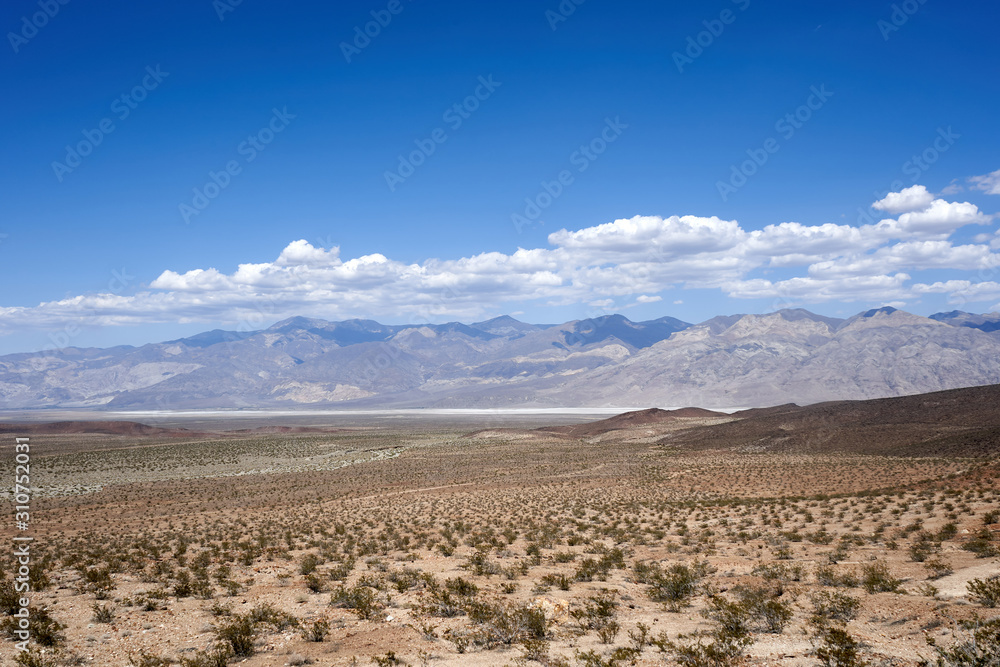 Mojave Desert. In southern California, southeast of Sierra Nevada, north and east of Los Angeles, North America. Rocks are brown and gray. Clouds in the blue sky