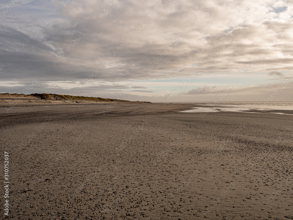 Norderney, Germany. 7 December 2019. Stony beach on the wetlands of the German North Sea coast on the island of Norderney with low clouds. Norderney, Germany. 7 December 2019. Stony beach on the wetlands of the German North Sea coast on the island of Norderney with low clouds.