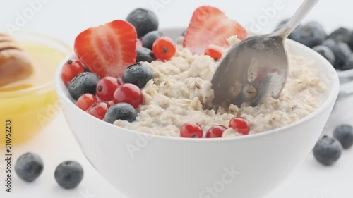 Bowl with oatmeal and berries with a spoon. Healthy breakfast concept