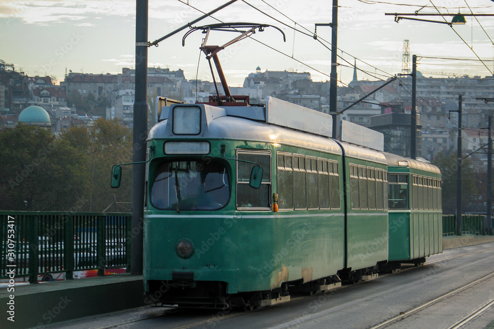 An old green tram in Belgrade is driving over the Stari savski most in belgade - old Sava bridge.