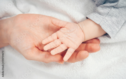 Close up baby hand on mother's hands