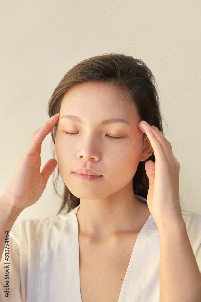 A woman demonstrating temple massage. A woman demonstrating temple massage.