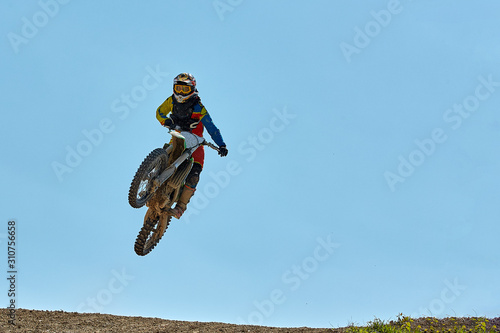 Fototapeta Naklejka Na Ścianę i Meble -  Extreme sports, motorcycle jumping. Motorcyclist makes an extreme jump against the sky. Film grain effect, illumination