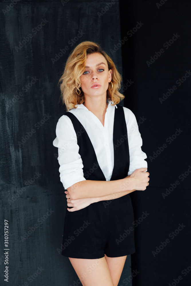 portrait of a beautiful fashionable blonde woman in black shorts white blouse portrait of a beautiful fashionable blonde woman in black shorts white blouse