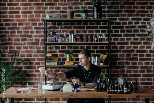 Perfumer mixing ingredients at table