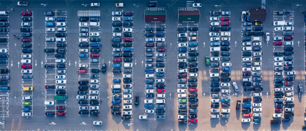 Bird's eye aerial view from drone parking lot with colored cars on a gray asphalt background. Top view strictly above. Bird's eye aerial view from drone parking lot with colored cars on a gray asphalt background. Top view strictly above.