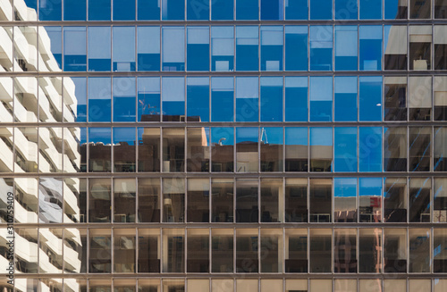 Fotografie Fachada de un edificio acristalado donde se reflejan el resto de edificios