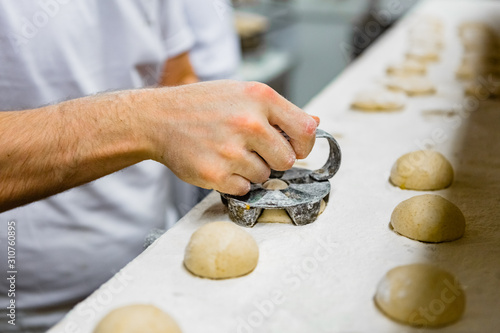 Pressing Iron Mold on Small Bread Loaves photo