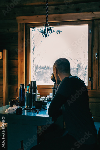 Anonymous Man Drinking Tea Inside Rustic Cabin