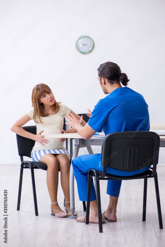 Obraz premium Pregnant woman visiting male doctor gynecologist