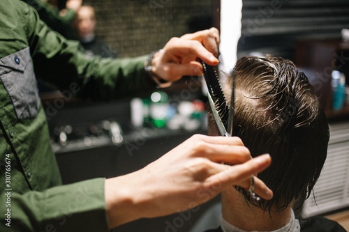 Men's hairstyling, haircutting, in a barber shop or hair salon. © Michael