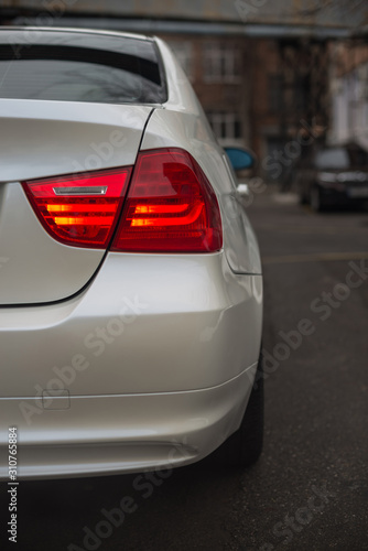 Detail of the rear light of a white car. © alexdemeshko