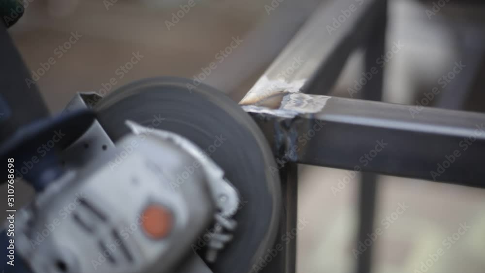Grinding metal with a circular saw. Processing a metal structure with a