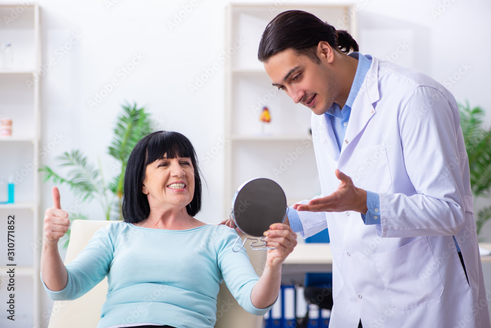 Obraz premium Old woman visiting young doctor dentist