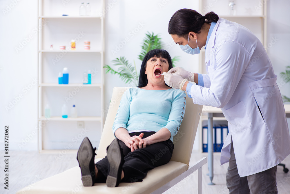 Fototapeta premium Old woman visiting young doctor dentist