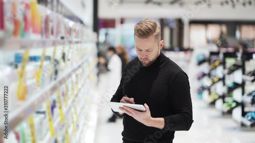 Man checks product and description on price tags in cosmetics store