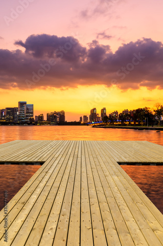 Wooden board square and Suzhou city skyline at sunset.