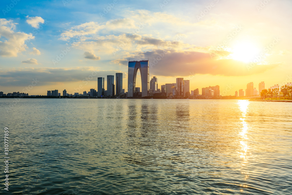 Suzhou city skyline and water reflection at sunset.