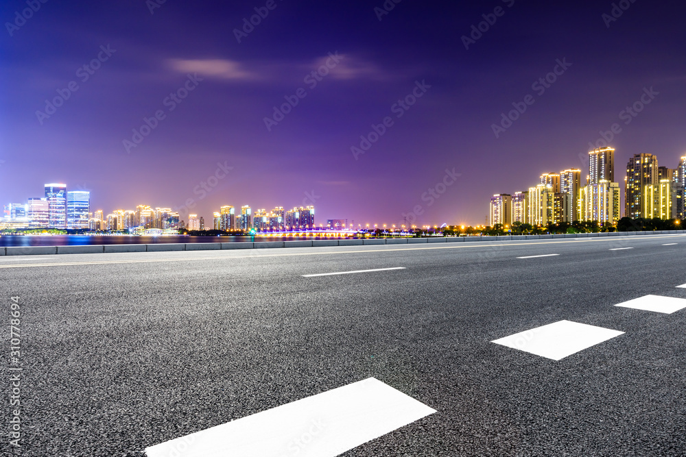 Asphalt road and Suzhou city skyline with beautiful colorful clouds at night.