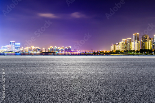 Asphalt road and Suzhou city skyline with beautiful colorful clouds at night. © ABCDstock