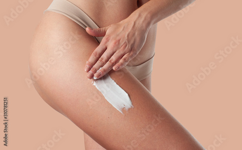 Obraz na płótnie Body care. Woman applying anti cellulite cream on legs.