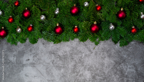 Christmas background with White and red ornaments, festive decor, fir tree branches on gray granite .